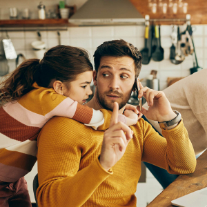 iStock-1312241725_copyright-Drazen-Zigic_square Mann arbeitet zuhause mit Laptop am Küchentisch, telefoniert und wird von seiner kleinen Tochter abgelenkt. Copyright: Drazen Zigic, iStock #1312241725