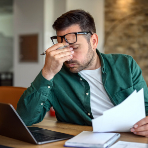 iStock-2162997902__copyright-Moon-Safari_square Mann sitzt erschöpft vor seinem Laptop, reibt sich die Augen. Copyright: Moon Safari, iStock #2162997902